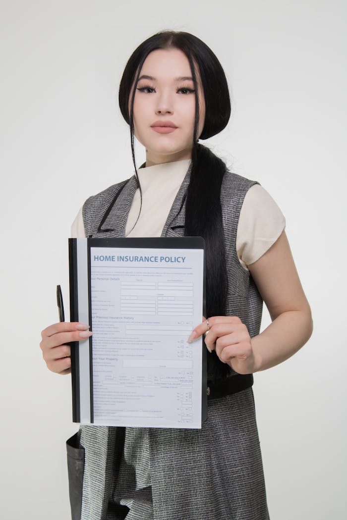 Confident woman holding a home insurance policy to showcase coverage details.